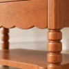 Close-up of turned bobbin legs and scalloped edge