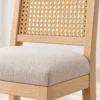 Close-up of woven cane back and padded stool seat