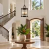Tall glass lantern pendant in a double-height Caribbean villa foyer