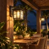 Black grid glass wall lantern glowing on a pergola post at night