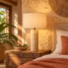 Travertine cylinder table lamp on a timber nightstand in a boutique hotel room