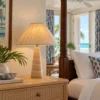 Travertine table lamp with ikat shade beside a four-poster bed in a Caribbean suite