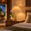 Travertine table lamp with rattan shade glowing in a hotel room at night
