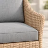 Close-up of hand-woven PE wicker on a loveseat arm